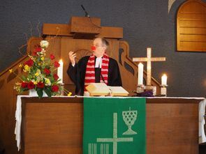 Pfarrer Kunze aus Wahnheide predigt mit Pappnas 